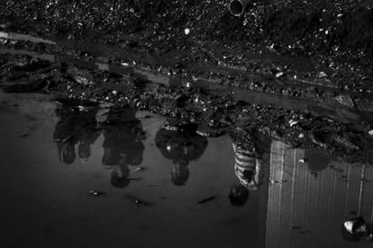 Un grupo de niños que huyeron de los combates en Mosul se reflejan en un charco del campo Sewdinan para desplazados internos, situado  cerca del pueblo Hasan Sham, a unos 35 kilómetros de Mosul.