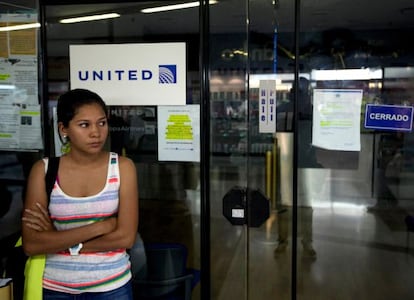 Uma mulher espera diante de um escritório da United em Caracas.