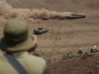 Un soldado israel&iacute; observa la evoluci&oacute;n de unos carros de combate durante unas maniobras militares de Israel cerca de Ein Zivan, en los Altos del Gol&aacute;n. 