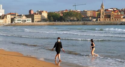 Una mujer se baña en la mañana de hoy lunes en la playa de San Lorenzo de Gijón. 