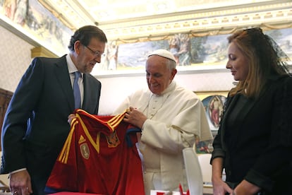 El presidente del Gobierno, Mariano Rajoy, acompañado de su esposa, Elvira Fernández, entrega al Papa Francisco una camiseta de la selección española de fútbol, durante la primera audiencia papal al presidente del Ejecutivo español el 15 de abril de 2013.