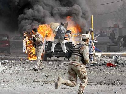 Soldados iraquíes junto a un coche bomba instantes después de la explosión el jueves en Bagdad.