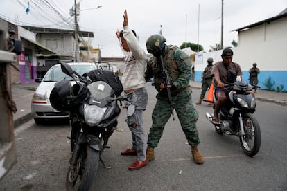 Militares revisan a conductores en un puesto de control antes de la segunda vuelta de las elecciones presidenciales, en Durán, Ecuador.