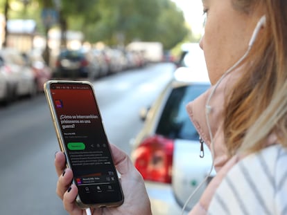 Una persona escucha un podcast de EL PAÍS en la calle, en Madrid.