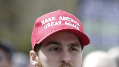 Un seguidor llevando una gorra con el lema de campaña de Donald Trump