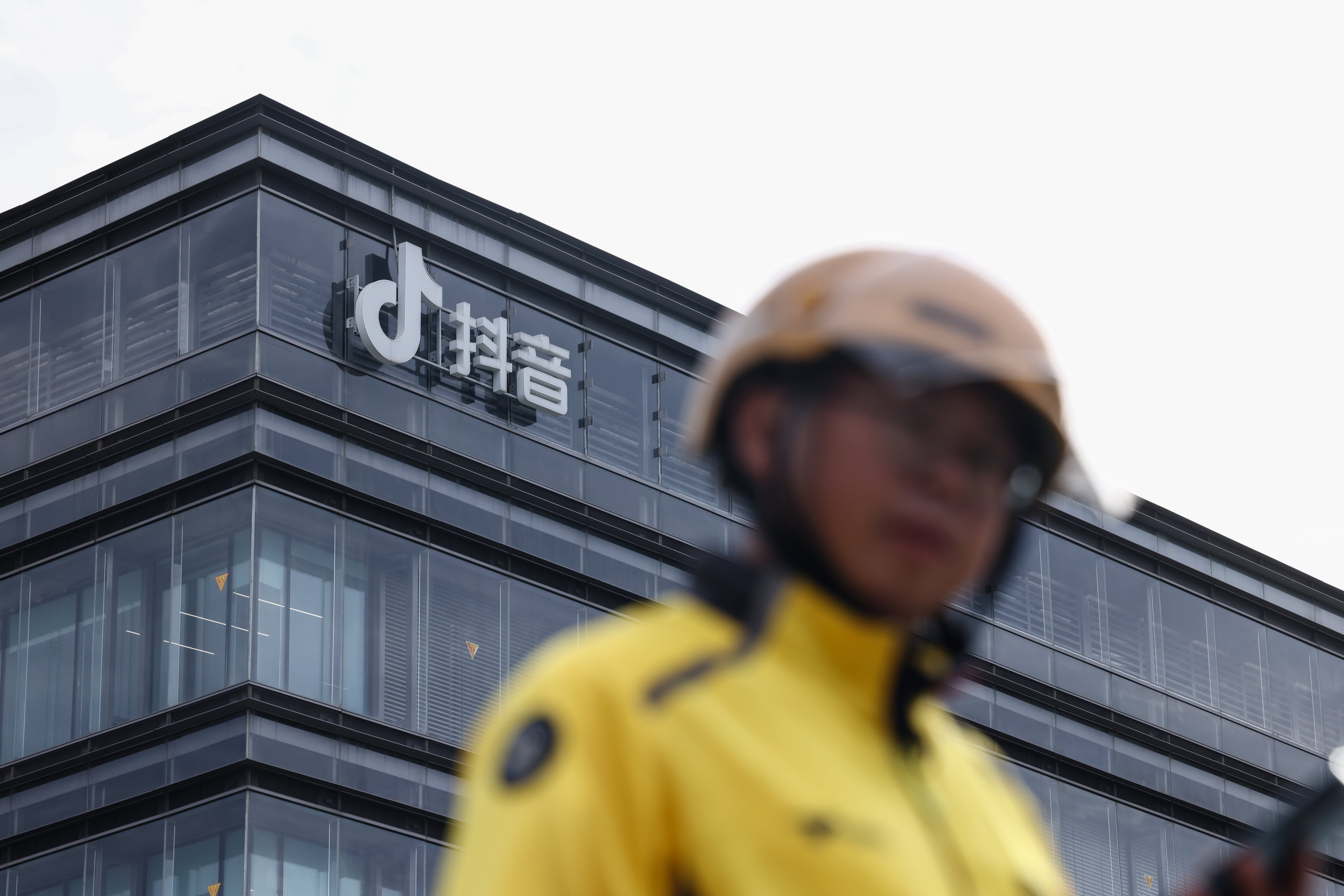 Un repartidor pasa frente a una oficina de ByteDance con el logotipo de Douyin, la contraparte china de TikTok, en Pekín, China, el 16 de septiembre. 
