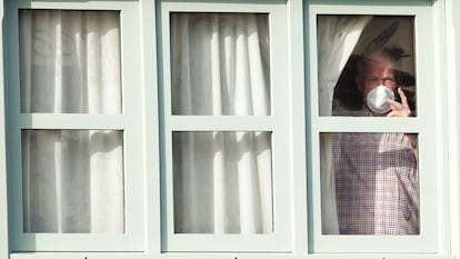 Un turista mira desde la ventana del hotel H10 Costa Adeje, este domingo. EFE