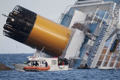 Miembros de los equipos de rescate italianos se aproximan al crucero siniestrado para proseguir la búsqueda de víctimas dentro y fuera del buque.