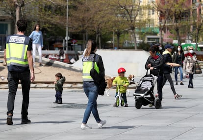 Policías patrullan entre niños y niñas en las calles de Madrid el segundo día en que pueden salir.