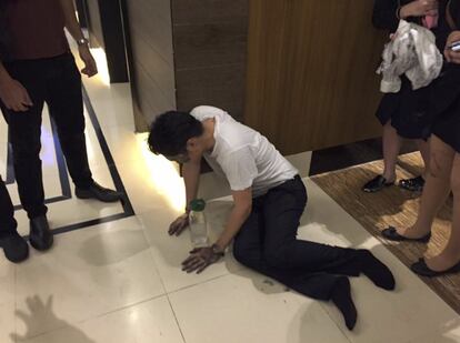 Un hombre sentado en el suelo del hotel.