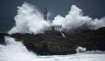 Una ola rompe en el faro de la Isla de Mouro, frente a la Península de la Magdalena (Santander).