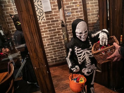 A child goes trick-or-treat at a restaurant on Halloween, in New York City, 2019.