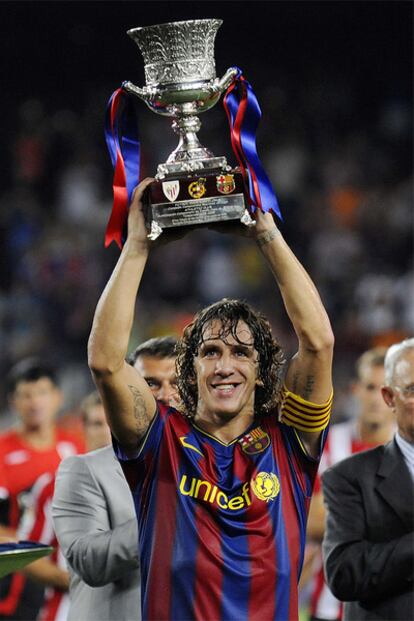Puyol alza el trofeo que acredita al Barça como último campeón de la Supercopa de España.
