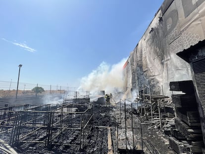 Varios bomberos refrescan la zona de almacenaje del Bricomart de Alcorcón afectada por las llamas.