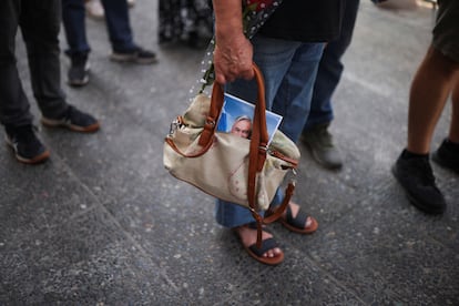 Una mujer lleva una fotografía de Piñera en su bolsa de mano, en la fila para visitar el velorio, este jueves en Santiago.