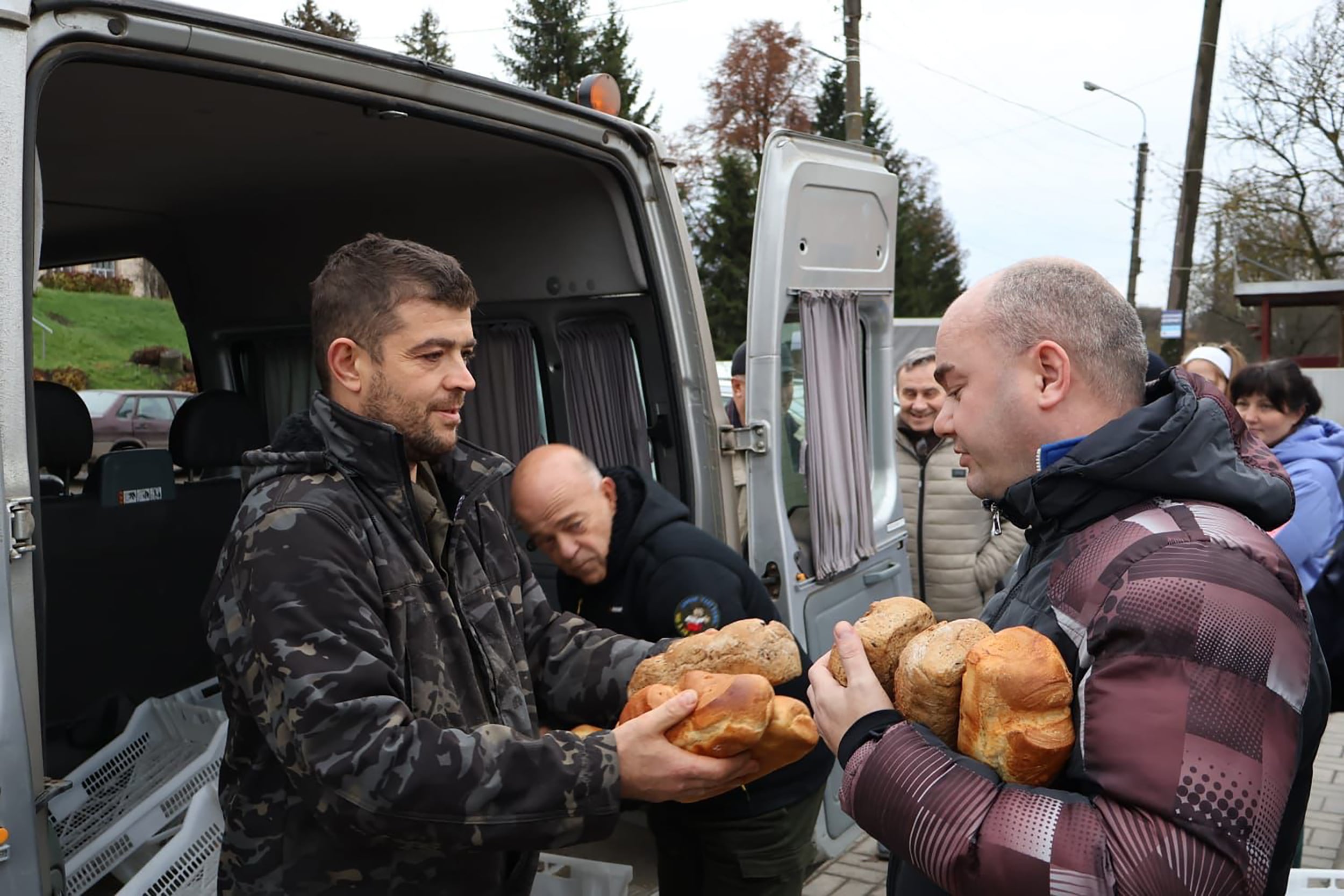 Loic Nervi reparte pan a vecinos ucranios durante una misión humanitaria en Ucrania, en una foto cedida por el panadero.