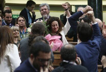 Aplauso general del hemiciclo a la diputada de En Comú Podem, Aina Vidal (emocionada, en el centro de la imagen), que a pesar de estar enferma ha acudido al pleno para votar en la investidura. Pablo Iglesias ha iniciado su intervención agradeciéndole su presencia en el Congreso y todos los diputados la han arropado con un largo aplauso. Ella misma explicó el pasado domingo, cuando no pudo acudir a la primera votación de investidura, que se había ausentado porque padece cáncer y le había sido imposible acudir. Aseguró entonces que sí estaría en la votación del martes, clave para sacar adelante el Gobierno de coalición del PSOE y Unidas Podemos.