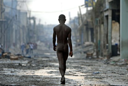 Un joven trastornado camina desnudo entre los escombros de las calles de Puerto Príncipe