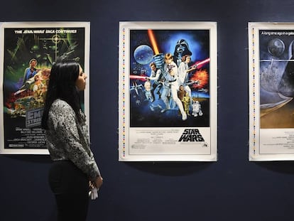 Una empleada de Sothebys observa unos carteles originales de las primeras películas de Star Wars que pondrá a subasta.