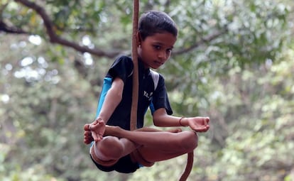 Un escolar indio practica yoga con cuerda en Bangalore (India).