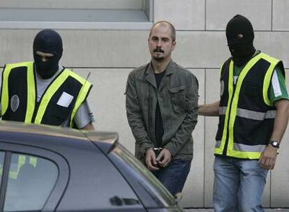 Asier Imaz abandona la comisaría de San Sebastián acompañado de varios agentes.