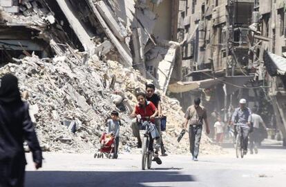 Ni&ntilde;os en bicicleta en un suburbio de Damasco.