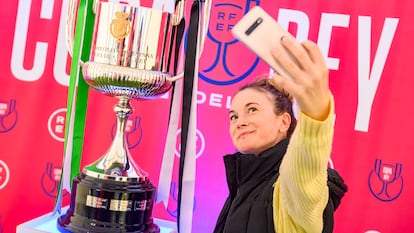 Una aficionada se fotografía junto a la Copa del Rey, que se expone en Metropol Parasol en Sevilla.