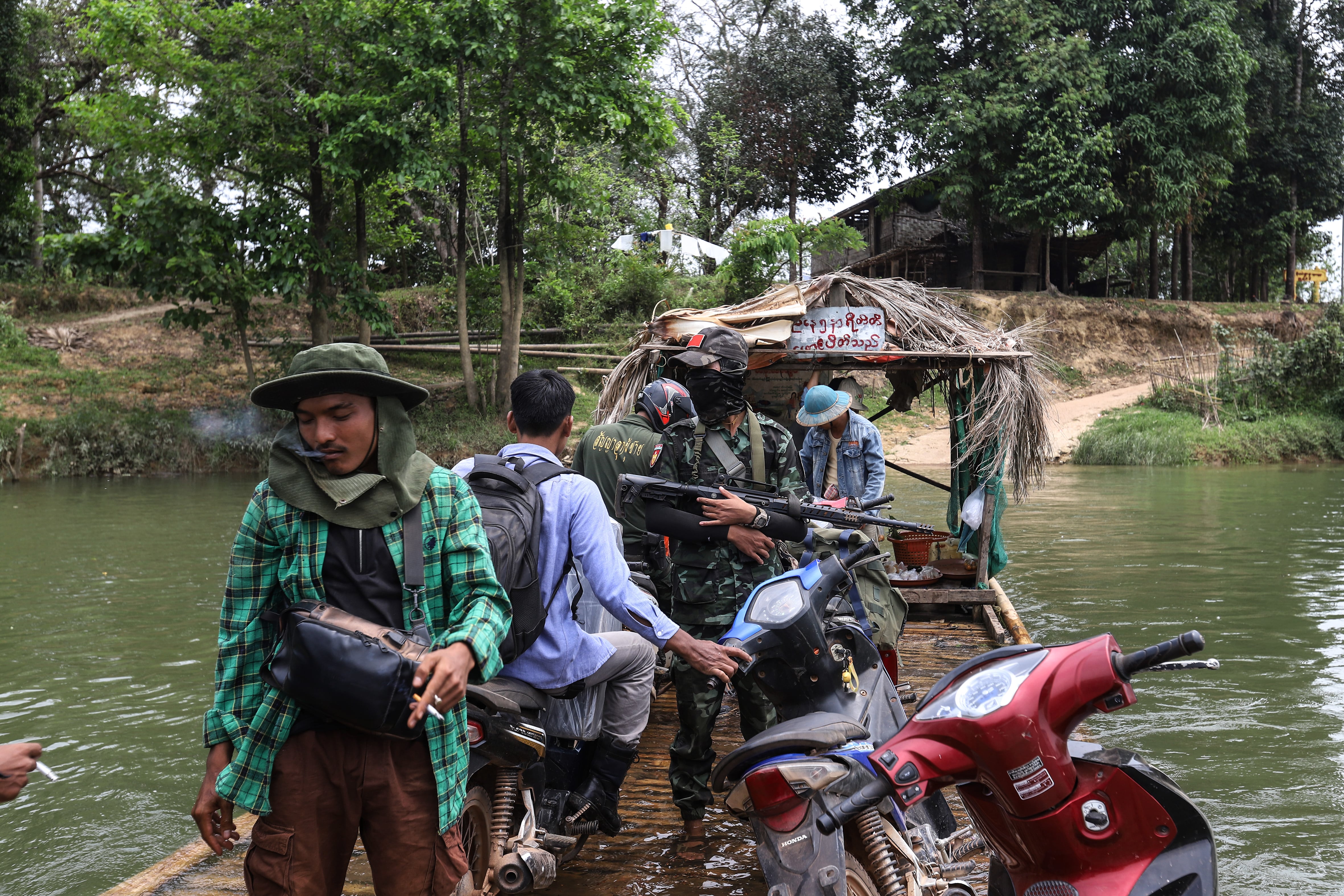 Combatientes de la Fuerza de Defensa del Pueblo cruzan el río en barca cerca de la línea del frente en la región de Tanintharyi, Myanmar el 21 de marzo de 2024. 