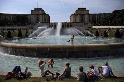 Un grupo de jóvenes toma el sol y se refresca en un estanque en la explanada de Trocadero en París (Francia), el 24 de junio de 2019. Las temperaturas en el país se han elevado a 33 grados centígrados. Los meteorólogos explican que los europeos sentirán un calor abrasador esta semana con temperaturas que se elevarán hasta los 40 grados centígrados en una 'ola de calor' sin precedentes "en junio que afectará a gran parte de Europa occidental.