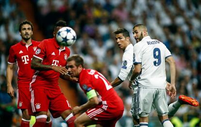 Cristiano Ronaldo (segundo por la derecha) y Benzema, jugadores del Real Madrid, observan la trayectoria del balón.