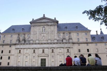 Cinco jóvenes sentado frente al Monasterio de San Lorenzo de El Escorial por la tarde, al salir de los cursos de verano de la Complutense.