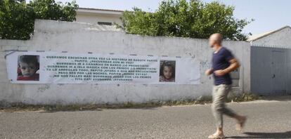 Un vecino observa un cartel sobre los niños desaparecidos en Córdoba en la finca familiar de José Bretón.