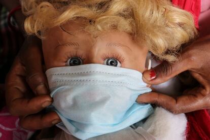 "Los ojos temerosos de la muñeca nos dicen que el virus puede estar en cualquier parte. Así que pongámonos la mascarilla para estar protegidos". Así, una madre de una aldea remota de Bangladés enseña a sus hijos cómo usarla poniéndosela a su juguete preferido.