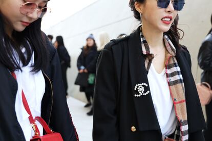 Una de las invitadas combinó una clásica camisa de Burberry con una chaqueta negra que acompañó con un broche de perlas de Chanel.