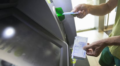 Un usuario retira efectivo en un cajero autom&aacute;tico de Madrid. 