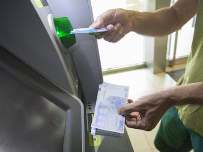 Usuário retira dinheiro de um caixa eletrônico em Madri.