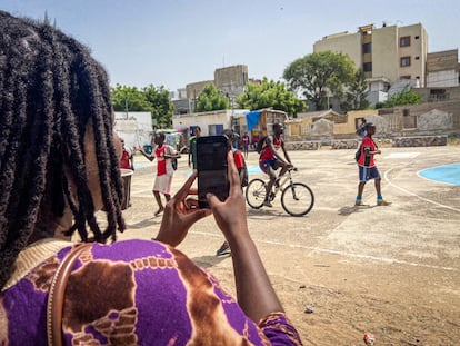 Maïmouna Elle Traoré hace una foto de un grupo de jóvenes que juegan al baloncesto en el barrio de Sicap-Amitie, en Dakar, el 27 de octubre de 2024.