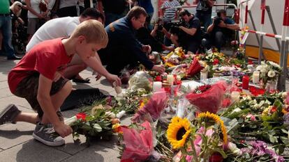 Ciudadanos ponen flores y velas en el exterior del centro comercial donde tuvo lugar el tiroteo.