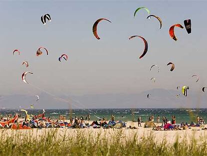 Los kitesurfistas llenan el cielo de la playa de Valdevaqueros con un espectacular baile de cometas. La práctica de esta modalidad de surf se ha multiplicado en los últimos años en la costa de Tarifa (Cádiz).