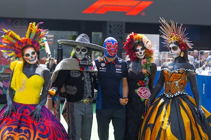 Checo Pérez, con una máscara de luchador, junto a las modelos vestidas de catrinas mexicanas.