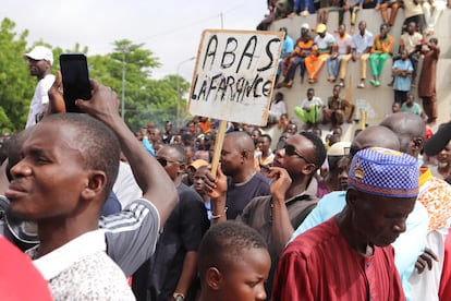 Manifestante sostiene un cartel con el mensaje "Abajo Francia" en Niamey Níger