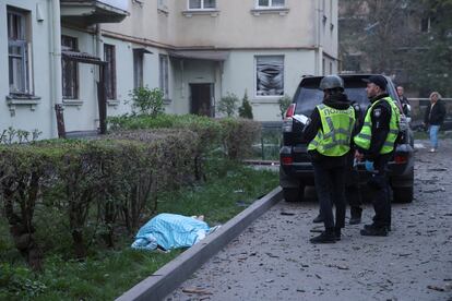 Agentes de policía, junto al cuerpo de una persona fallecida  del ataque ruso en un barrio de Kiev, este jueves.