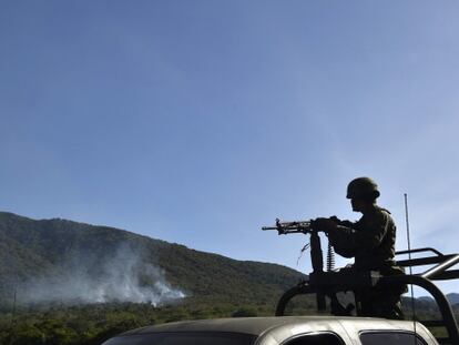 Un soldado junto a un helicóptero derribado en Jalisco.