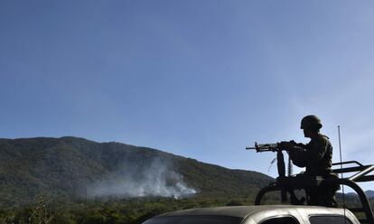 Un soldado junto a un helicóptero derribado en Jalisco.