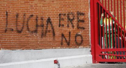 Un trabajador se asoma dese el interior de un cant&oacute;n en Carabanchel.