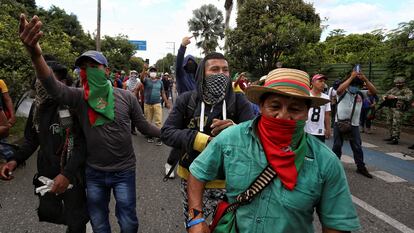 Indígenas caminham por uma rua durante uma manifestação em Cali, neste domingo. Em vídeo, o momento em que um grupo de civis armados se retira após abrir fogo contra a ‘minga’.