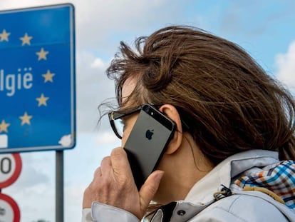 Una dona fa servir el seu mòbil a la frontera entre França i Bèlgica.