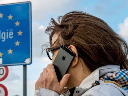 Una dona fa servir el seu mòbil a la frontera entre França i Bèlgica.