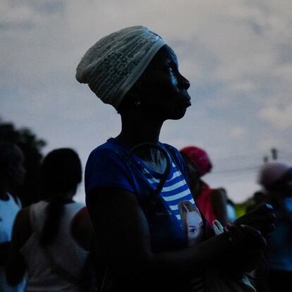 FILE PHOTO: A woman waits to get a once-monthly ration of chicken, during a blackout, at a small state-run market in Santiago, Cuba, March 20, 2024. REUTERS/Alexandre Meneghini/File Photo