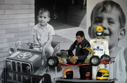 Un hombre se encuentra enmarcada por las imágenes del piloto de Fórmula 1 Ayrton Senna, cuando era un muchacho, junto a un kart en exhibición en el circuito de Imola, Italia, el 30 de abril 2014. Los aficionados y miembros de la familia se reúnen esta semana para pagar presentar sus respetos a los ex pilotos de Fórmula 1 Ayrton Senna y Roland Ratzenberger en el 20 aniversario de su muerte.